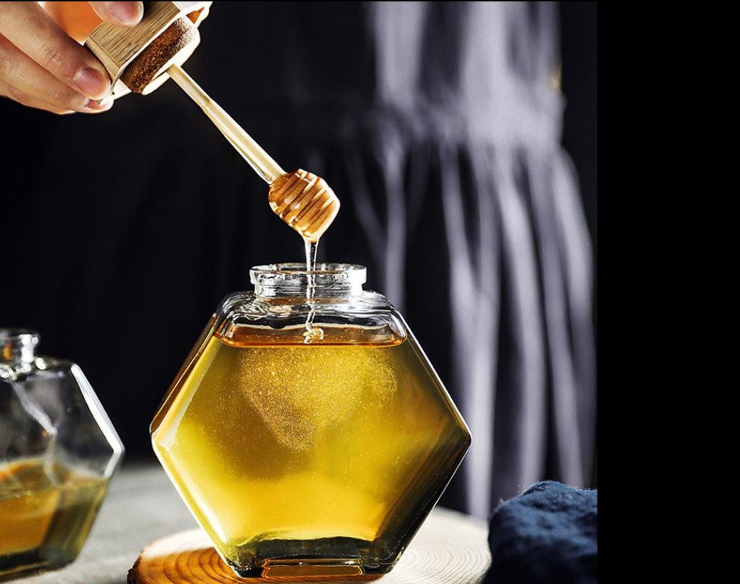 Raw honey with wooden dipper
